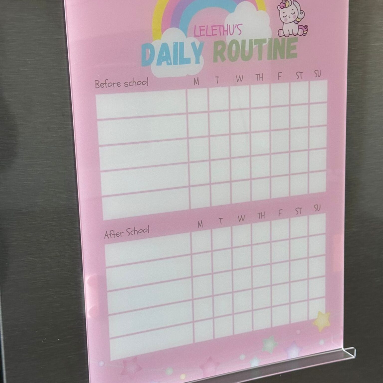 Pink unicorn daily routine chart on a fridge