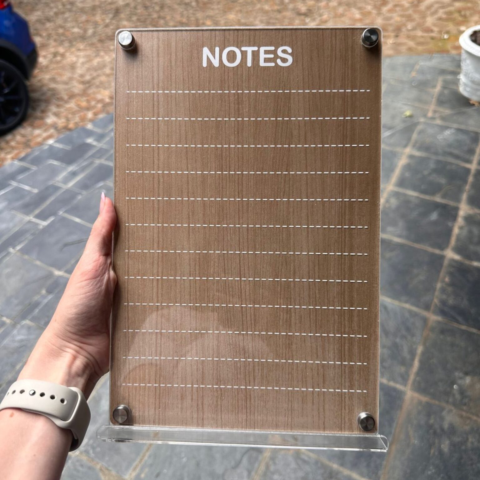 Wood-effect notes board with dashed lines on a desk stand