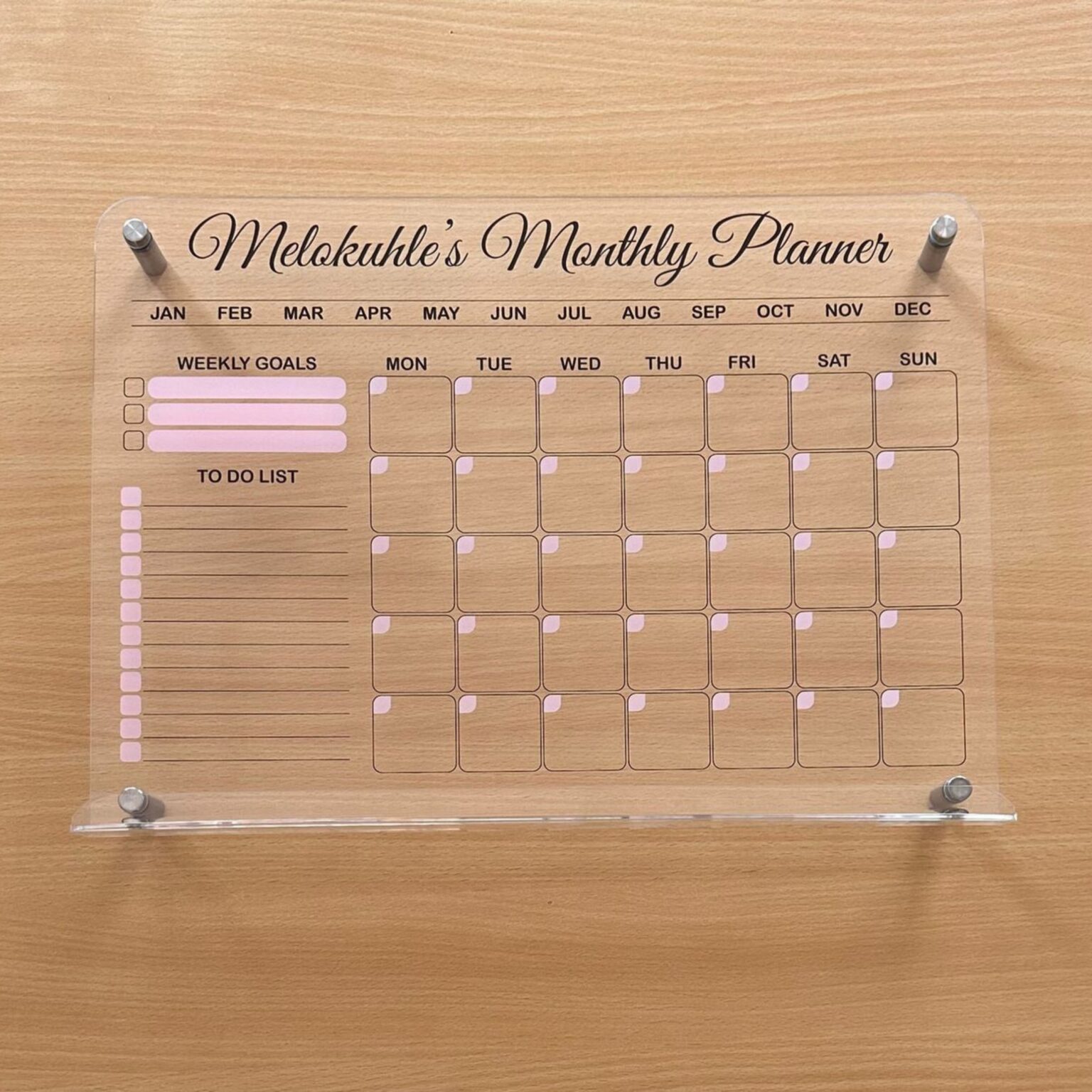 Personalised monthly planner with pink accents and stand-off pins