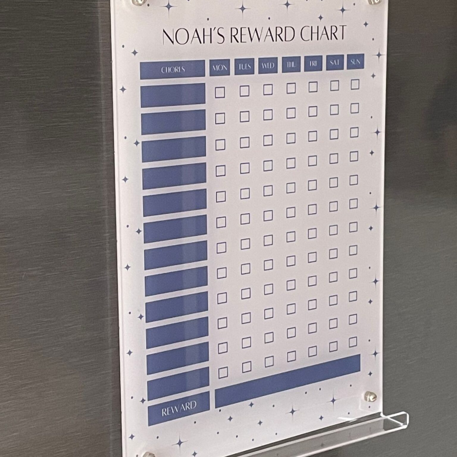 Navy reward chart mounted on a fridge with stand-off pins